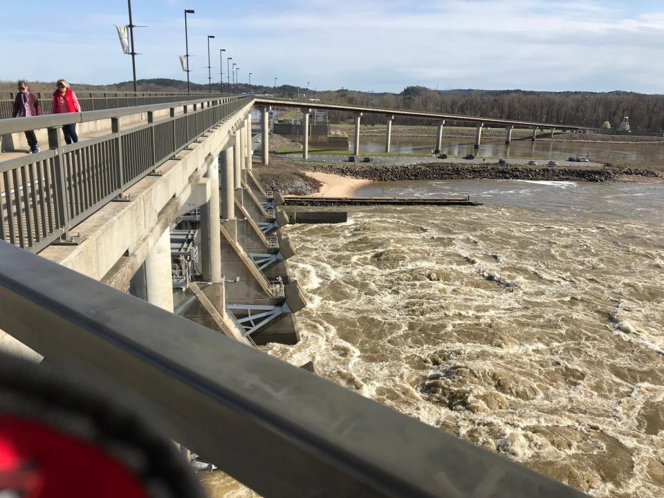 Water rushes below the Big Dam Bridge across the Arkansas River. It is the longest pedestrian-and-bicycle-intended bridge in America. The bridge tops Murray Lock and Dam. Native Americans from the southeastern United States traveled this section of the river during the Trail of Tears in the 1830s.