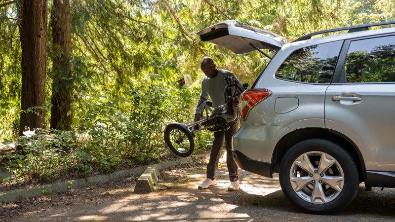 A photo of someone loading a RadTrike into their car. 