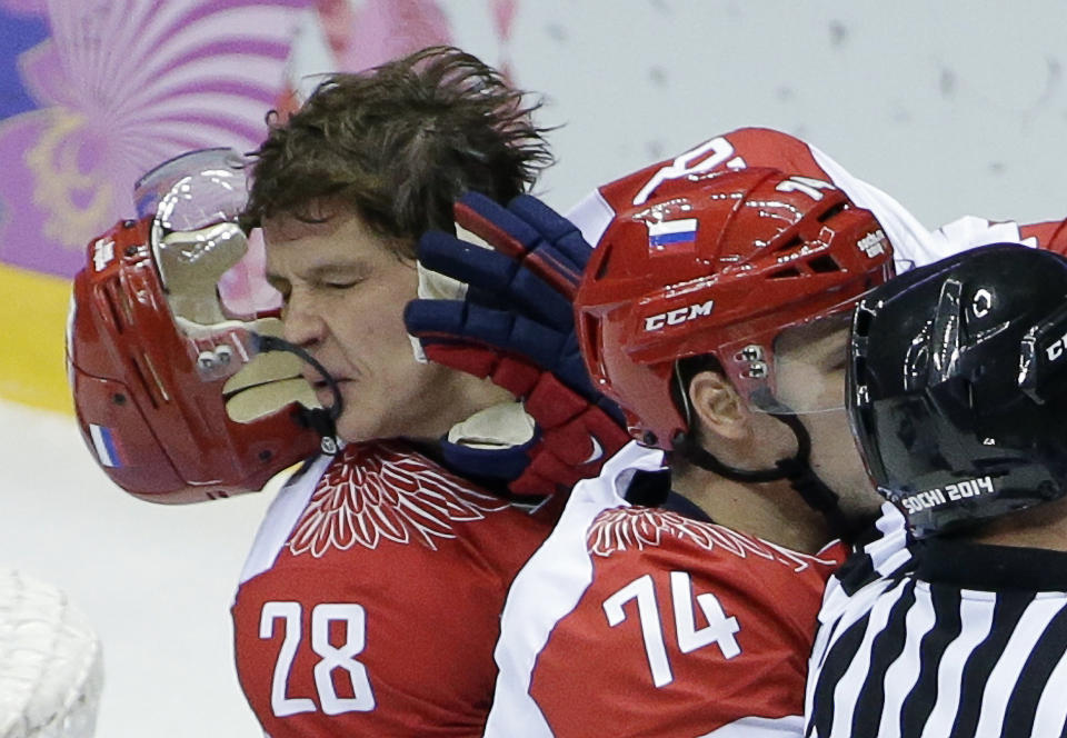 Russia forward Alexander Syomin has his helmet knocked from his head during a scuffle with the USA in the first period of a men's ice hockey game at the 2014 Winter Olympics, Saturday, Feb. 15, 2014, in Sochi, Russia. (AP Photo/David J. Phillip )