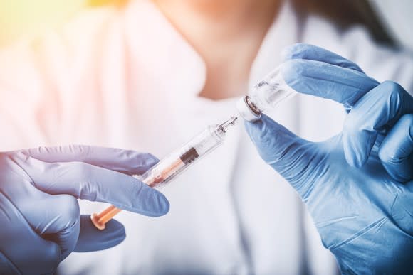 Medical professional holding syringe in vial