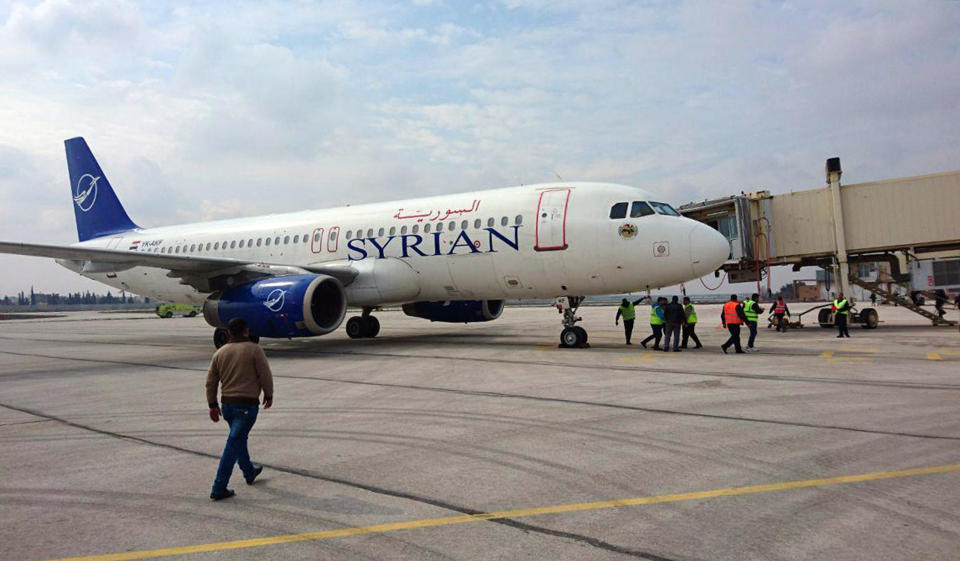 This photo released by the Syrian official news agency SANA, shows a Syrian commercial plane carrying Syrian officials and journalists after it landed at Aleppo airport, Syria, Wednesday, Feb. 19, 2020. The Syrian commercial flight on Wednesday from Damascus, marked the resumption of internal flights between Syria's two largest cities for the first time since 2012. (SANA via AP)