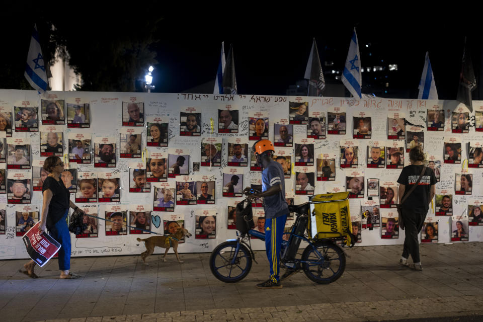 People look at a memorial for the more than 220 people captured by Hamas militants, in Tel Aviv, Israel, Saturday, Oct. 28, 2023. (AP Photo/Bernat Armangue)