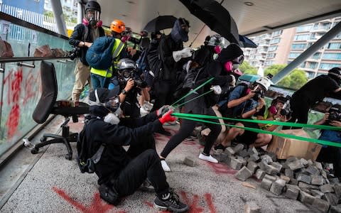 Protesters use a catapult against police during a protest Hong Kong's City University on - Credit: PHILIP FONG/AFP