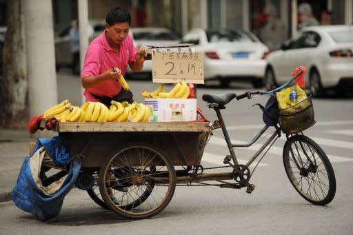 A vendor sells bananas from his tricycle on a street in Shanghai on July 9, 2012. China said on Friday its economy grew by 7.6 percent in the second quarter of 2012, the slowest pace in more than three years