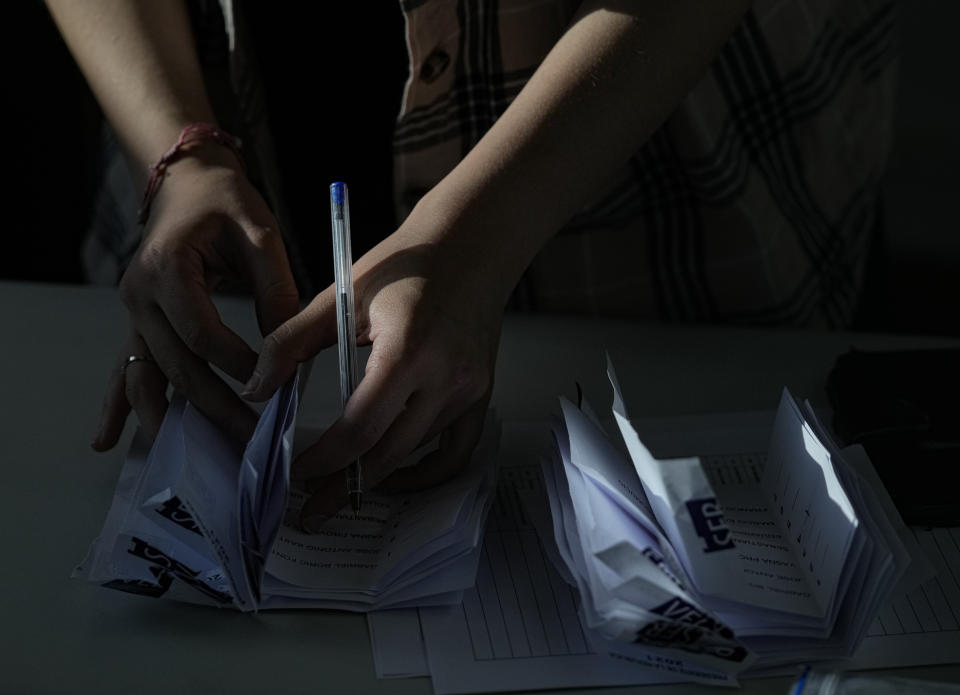 An electoral worker counts votes inside a polling station during presidential elections in Santiago, Chile, Sunday, Nov. 21, 2021. (AP Photo/Esteban Felix)
