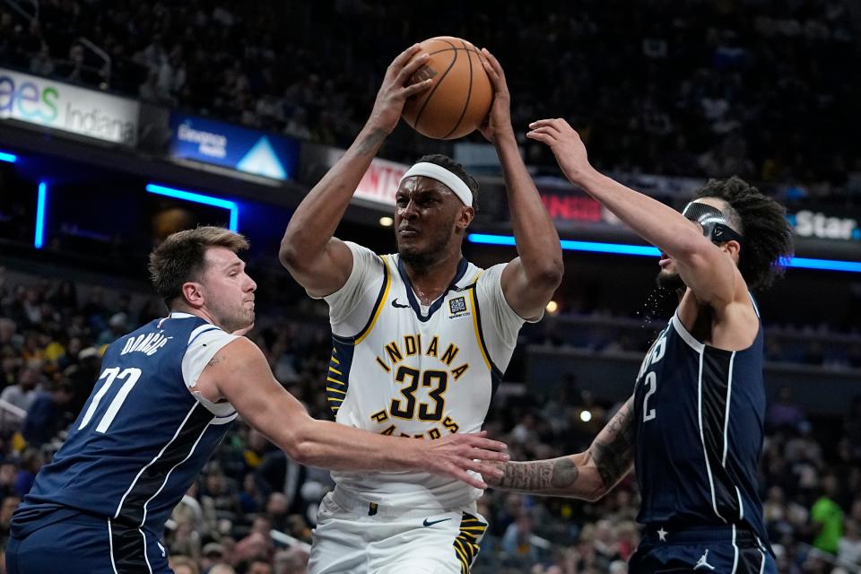 Indiana Pacers' Myles Turner (33) goes to the basket against Dallas Mavericks' Luka Doncic (77) and Dereck Lively II during the second half of an NBA basketball game, Sunday, Feb. 25, 2024, in Indianapolis. (AP Photo/Darron Cummings)