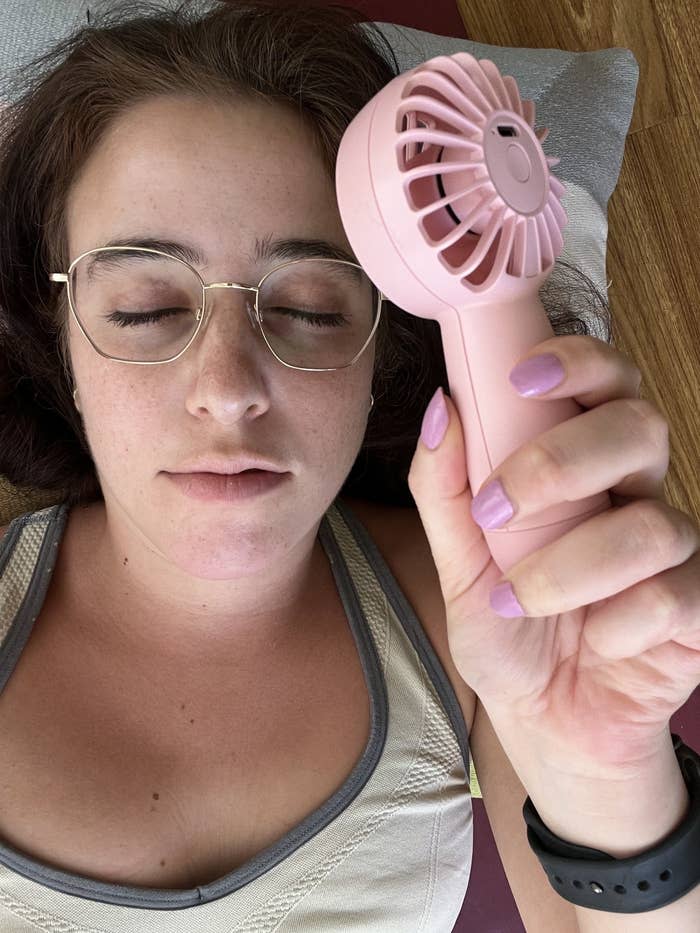 Woman with eyes closed and holding a fan