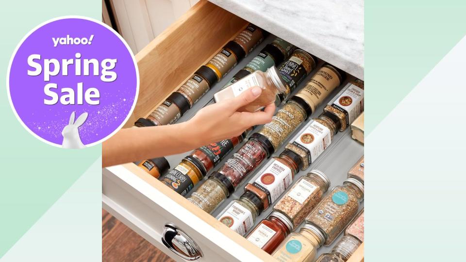 model holding spice above drawer with various spices neatly organized. 