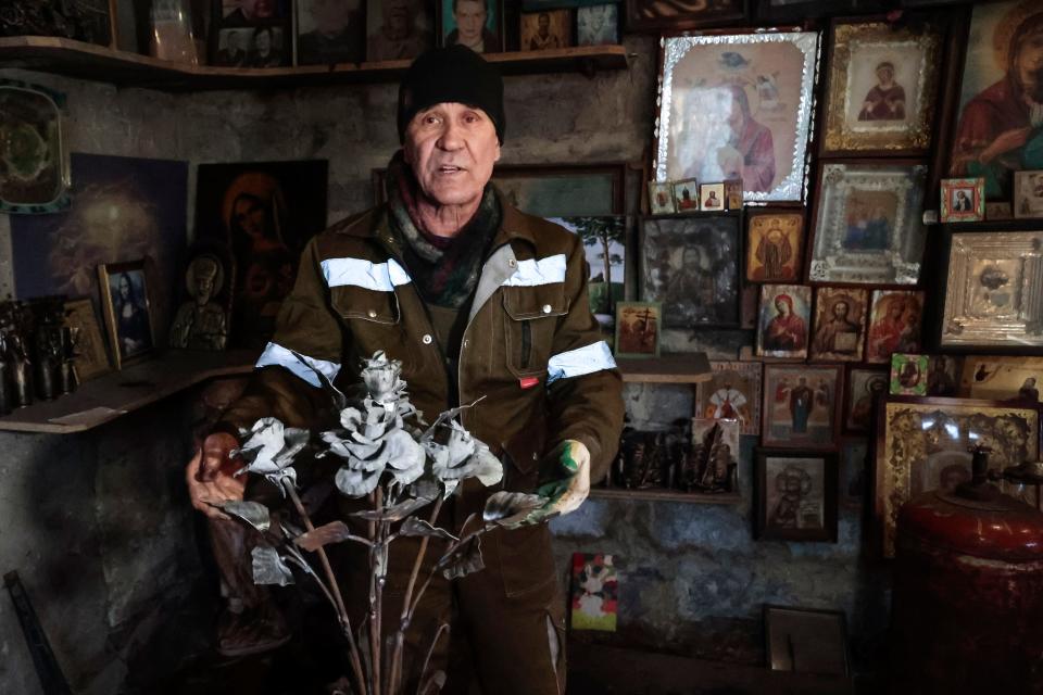 Viktor Mikhalev shows roses transformed from weapons and ammunition into flowers of war standing in a workshop in his house in Donetsk, Russian-controlled Donetsk region, eastern Ukraine, Saturday, March 4, 2023. Mikhalev, trained as a welder, lives and works in a house whose fence and door are decorated with forged flowers and grapes.