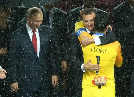 Soccer Football - World Cup - Final - France v Croatia - Luzhniki Stadium, Moscow, Russia - July 15, 2018 France President Emmanuel Macron embraces Hugo Lloris during the presentations as President of Russia Vladimir Putin looks on REUTERS/Michael Dalder