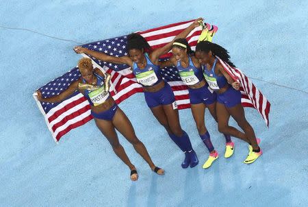 2016 Rio Olympics - Athletics - Final - Women's 4 x 400m Relay Final - Olympic Stadium - Rio de Janeiro, Brazil - 20/08/2016. Courtney Okolo (USA) of USA, Natasha Hastings (USA) of USA, Phyllis Francis (USA) of USA and Allyson Felix (USA) of USA pose with their national flags after winning the gold. REUTERS/Fabrizio Bensch