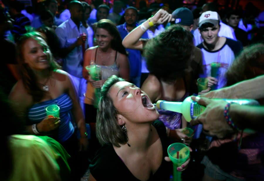 A woman drinks from the bottle at a nightclub in Cancun, Mexico, Tuesday, March 4, 2008, during Spring Break. (AP Photo/Israel Leal)
