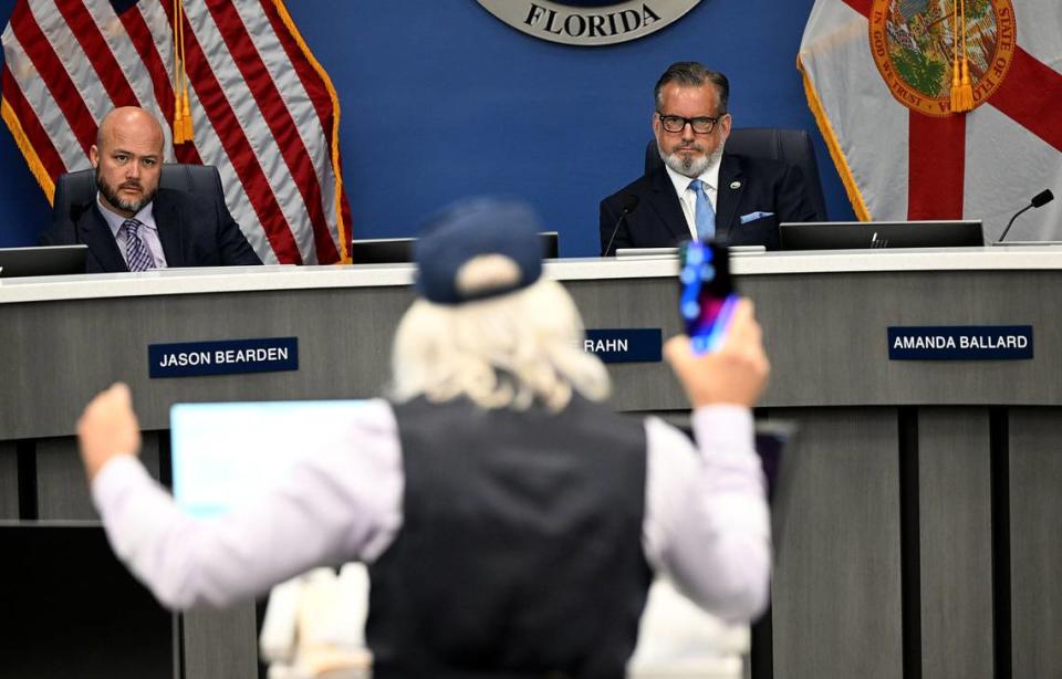 Commissioners Jason Bearden and Mike Rahn listen to Tim Ritchey, the founder and president of March against Mosaic during a meeting on Tuesday, Feb. 27, 2024.