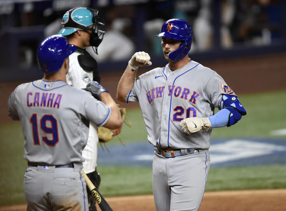 New York Mets Pete Alonso (20) celebrates after hitting a home run with teammate Mark Canha (19) during the eighth inning of a baseball game against the Miami Marlins, Friday, March 31, 2023, in Miami. (AP Photo/Michael Laughlin)