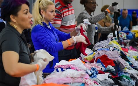 Volunteers at the George R Brown Convention Centre greet Houston residents seeking shelter - Credit: The Daily Advertiser via AP