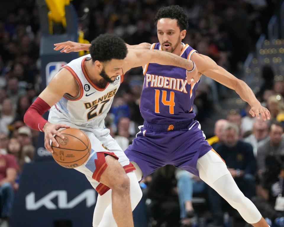 Phoenix Suns guard Landry Shamet (14) defends Denver Nuggets guard Jamal Murray (27) during the first quarter of the Western Conference semifinals at Ball Arena in Denver on May 9, 2023.