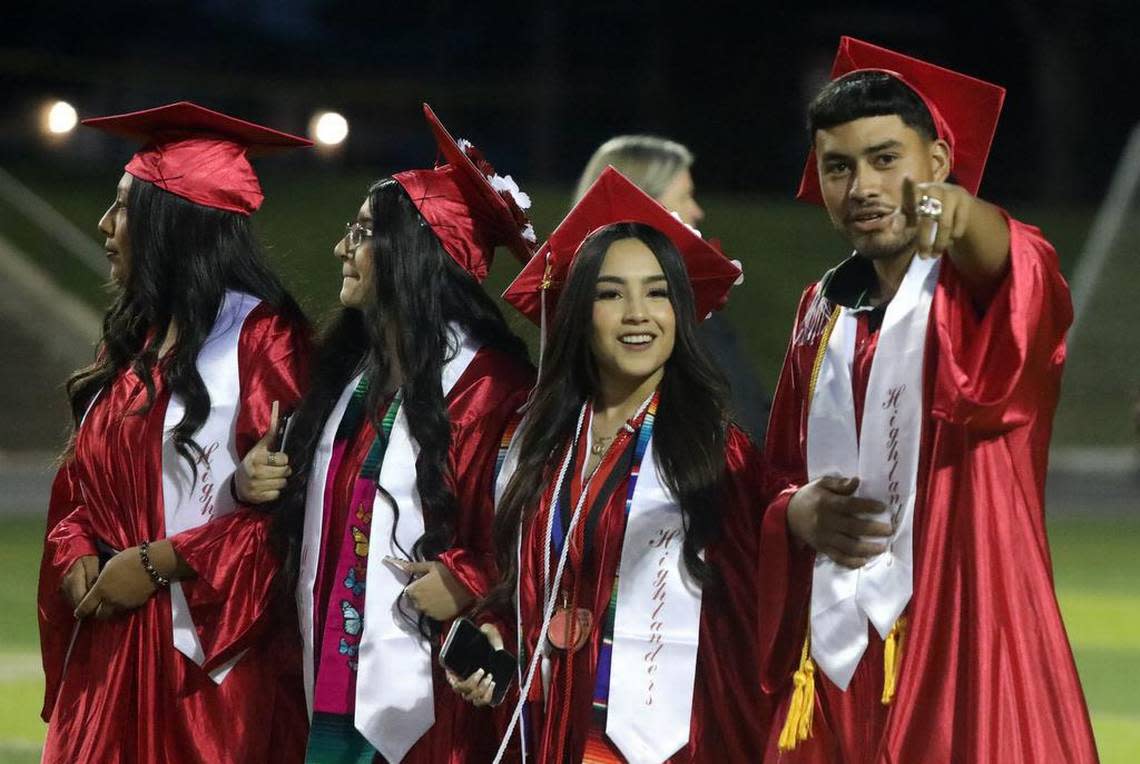 Graduates walk to their seats during the McLane High graduation at the school stadium on June 6, 2023.