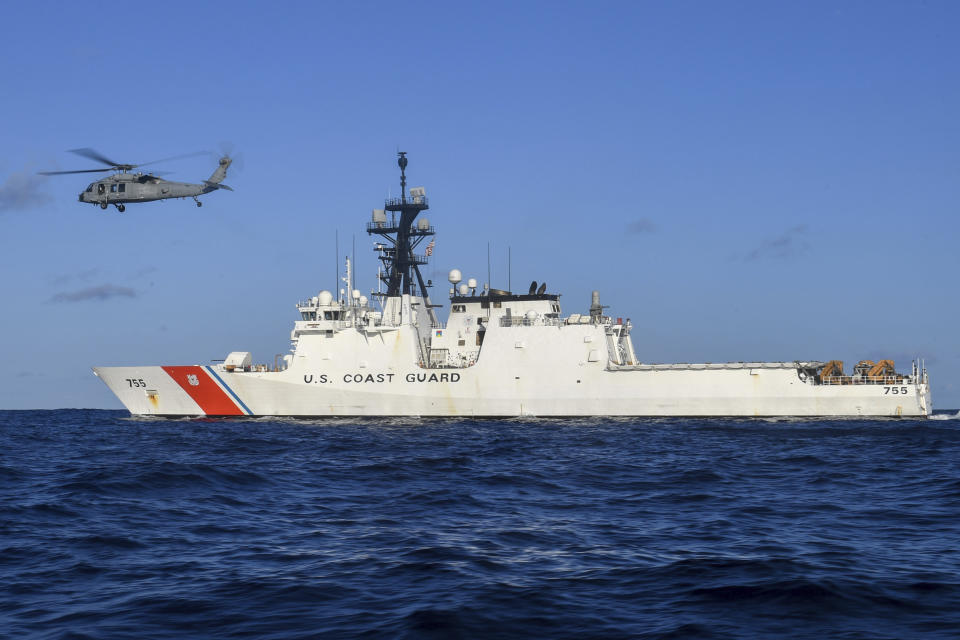In this Aug. 25, 2020 photo provided by the U.S. Navy, an MH-60S Sea Hawk Helicopter hovers next to the Legend-class cutter USCGC Munro in the Pacific Ocean. The Coast Guard cutter Munro had just embarked on a national security mission to patrol the maritime boarder between the United States and Russia in late June 2020, when one of its guardsman was diagnosed with COVID-19. Contract tracing led to more than a dozen other members of the ship's crew being ordered into quarantine for two weeks. (Mass Communication Specialist 3rd Class Madysson Anne Ritter/U.S. Navy via AP)