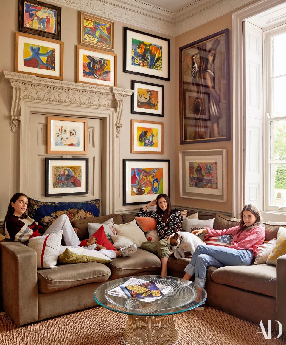 Brooke’s children Isabel, Ines, and Marina lounge on the sofa beneath oil paintings by Grace Pailthorpe. Warren Platner for Knoll coffee table.