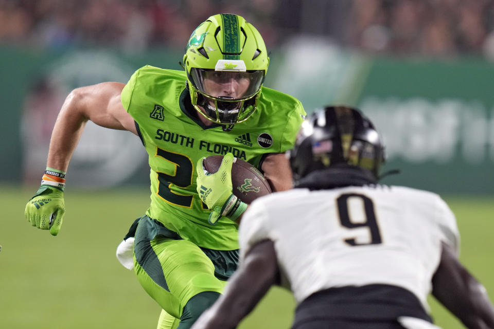 South Florida wide receiver Holden Willis (23) tries to put a move on UCF defensive back Divaad Wilson (9) after a catch during the first half of an NCAA college football game Saturday, Nov. 26, 2022, in Tampa, Fla. (AP Photo/Chris O'Meara)