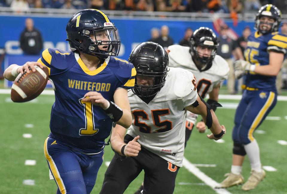 Quarterback Tre Eitniear of Whiteford of runs away from the pressure from Austin Gentner of Ubly in the fourth quarter as the Whiteford Bobcats came up short losing to Ubly 21-6 in the Division 8 State Finals 21-6 at Ford Field Saturday, November 25, 2023.