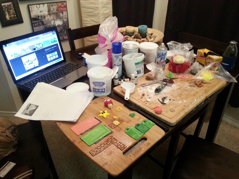 This undated photo provided by Justin Clark shows a baking station with decorations for a Mario Brothers-themed square cake in Dallas. Clark, an amateur baker, typically uses a layer of fondant to cover a simple round cake, and gets creative from there. Shows like Ace of Cakes, Cake Boss, and various spinoffs tempt viewers with stunning visions of creations closer to art than dessert. This is the era of 3-D baking, and the simple, square birthday cake is little more than a remnant of the past. (AP Photo/Justin Clark)