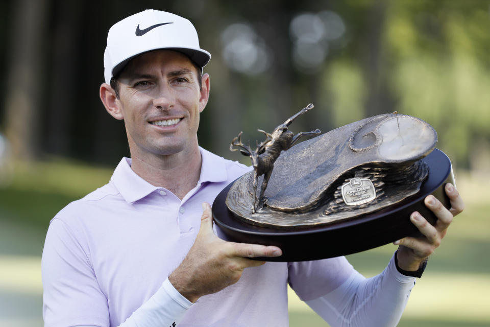 Dylan Frittelli holds the trophy after winning the John Deere Classic golf tournament, Sunday, July 14, 2019, at TPC Deere Run in Silvis, Ill. (AP Photo/Charlie Neibergall)