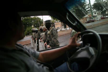 Soldiers keep watch minutes before the start time of a curfew enforced by Honduras government while the country is still mired in chaos over a contested presidential election in Tegucigalpa, Honduras, December 2, 2017. REUTERS/Edgard Garrido