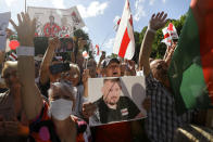 FILE - In this file photo taken on Sunday, Aug. 2, 2020, a man holds a poster with a portrait of Syarhei Tsikhanousky, husband of Sviatlana Tsikhanouskaya, who has remained in jail since his arrest in May on charges of assailing a police officer that he has dismissed as a provocation, during meeting in support of candidate for the presidential elections Sviatlana Tsikhanouskaya in the town of Baranovichi, 150 km (93 miles) southwest of Minsk Belarus. (AP Photo/Sergei Grits, FILE)