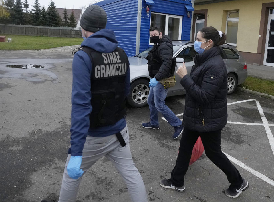 Polish Border Guard officers escort a Syrian woman from a hospital in Bielsk Podlaski, Poland, on Nov 22, 2021. The woman suffered a miscarriage after being trapped in a forest in Poland after crossing the border from Belarus, then she caught COVID-19 while being treated in a hospital. She is one of thousands of people who since this summer have tried to enter the European Union from Belarus in a new migration route opened by the Belarusian regime which Poland has sought to cut off, and which has become increasingly dangerous. (AP Photo/Czarek Sokolowski)