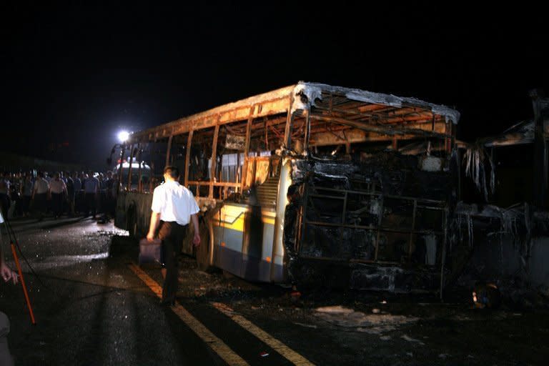 Investigators are seen at the scene where a bus caught fire on an elevated road in the city of Xiamen, China's southeast Fujian province, on June 7, 2013. An arsonist who wanted to "vent personal grievances" is suspected to have caused a horrific bus blaze in China which left 47 people dead, according to state media