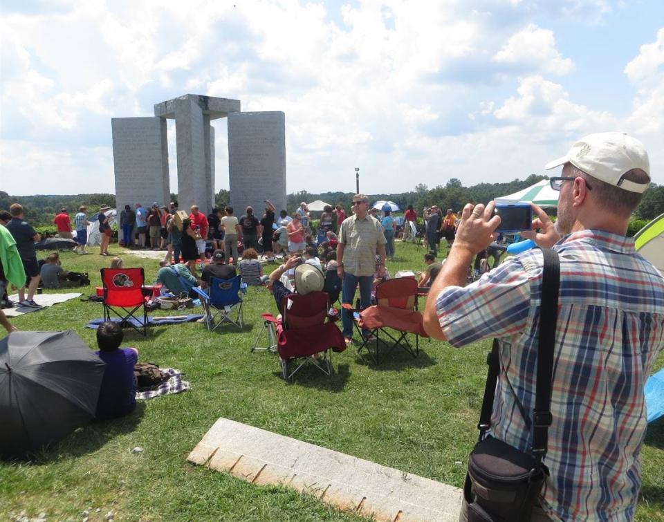 FILE - Prior to the solar eclipse of Aug. 21, 2017, people gathered around the Georgia Guidestones to experience the celestial event.