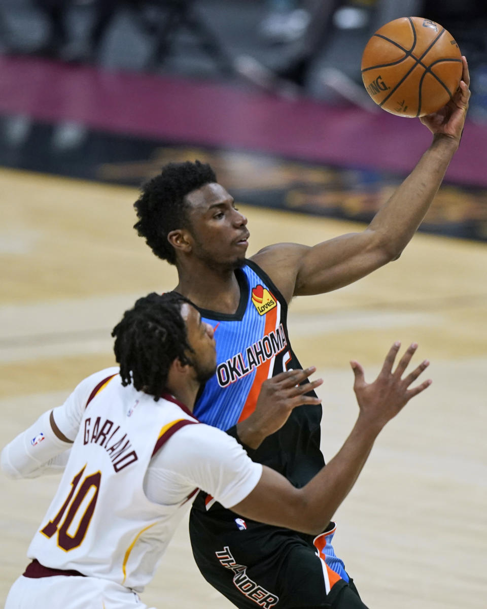 Oklahoma City Thunder's Hamidou Diallo, right, drives to the basket against Cleveland Cavaliers' Darius Garland during the second half of an NBA basketball game Sunday, Feb. 21, 2021, in Cleveland. (AP Photo/Tony Dejak)