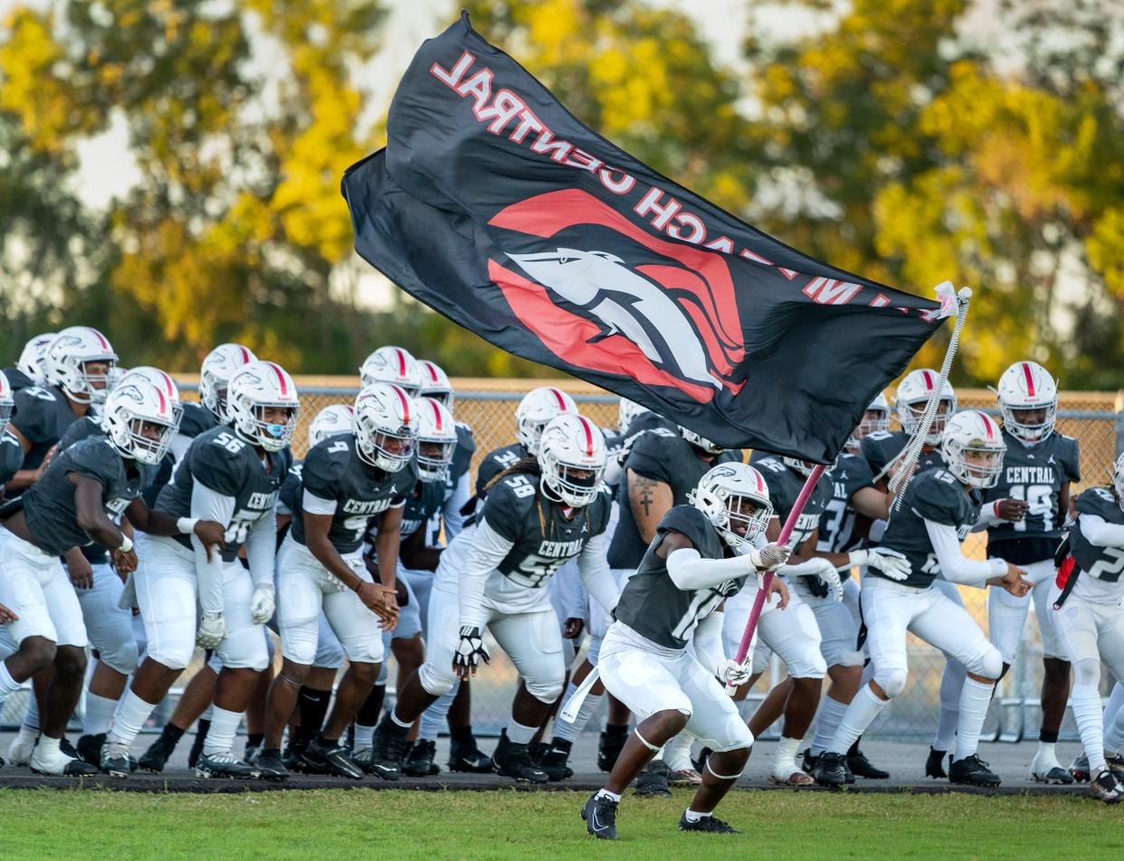 Palm Beach Central waves their flag and runs on to the field against Wellington during game on October 28, 2022.