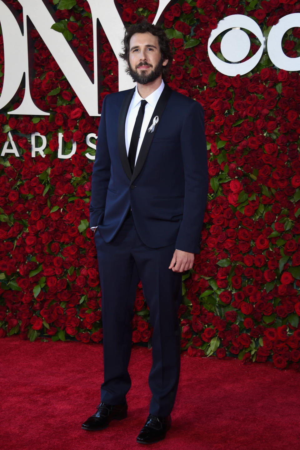 Josh Groban in a dark blue suit and black skinny tie 