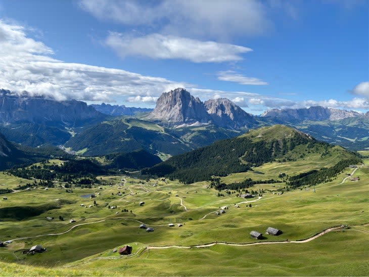 A photo of the mountains and green fields