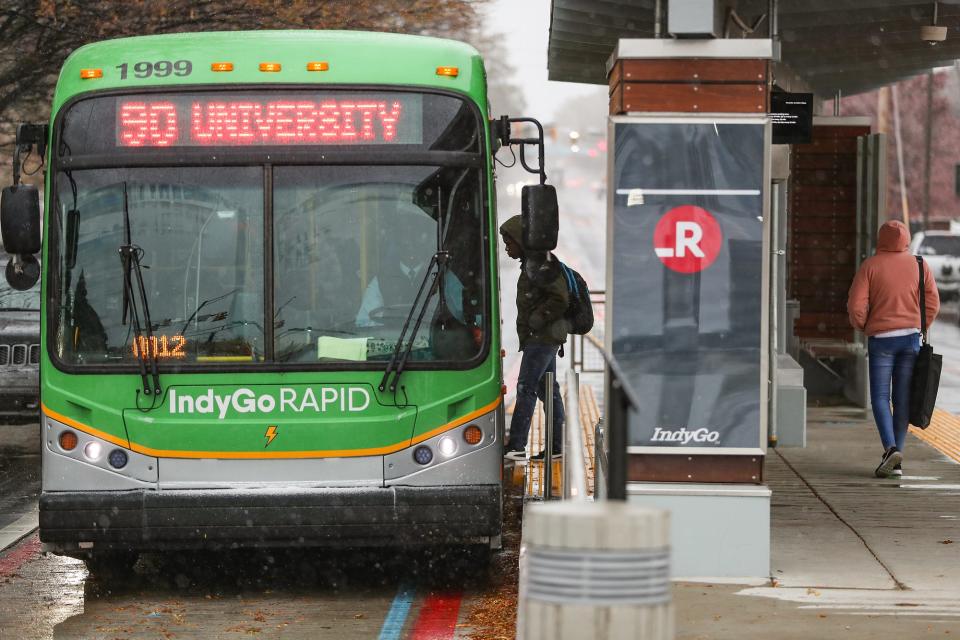 Passengers board the IndyGo Red Line near Fall Creek Parkway Drive, during afternoon snowfall on Monday, Nov. 11, 2019.