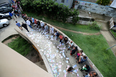 Brazilians stand in line outside a polling station to cast their votes in the presidential election, in Rio de Janeiro, Brazil October 7, 2018. REUTERS/Sergio Moraes