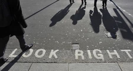 Workers cross the road in Whitehall in central London October 20, 2010. REUTERS/Toby Melville