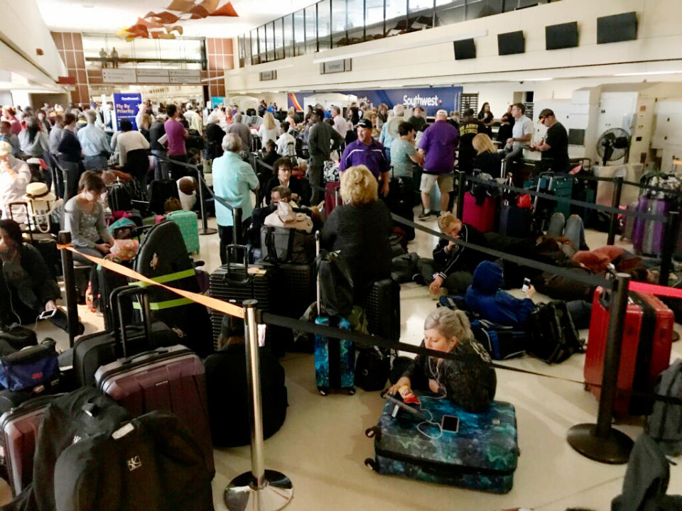 Crowds form at Louis Armstrong New Orleans International Airport after the remnants of Tropical Storm Olga knocked power out at the terminal early Saturday, Oct. 26, 2019. (David Grunfeld/The Times-Picayune/The New Orleans Advocate via AP)