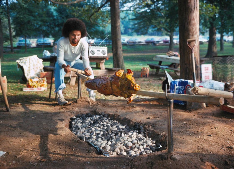 <p>Man roasting a pig. (Photo: Neal Boenzi/NYC Parks Photo Archive/Caters News) </p>