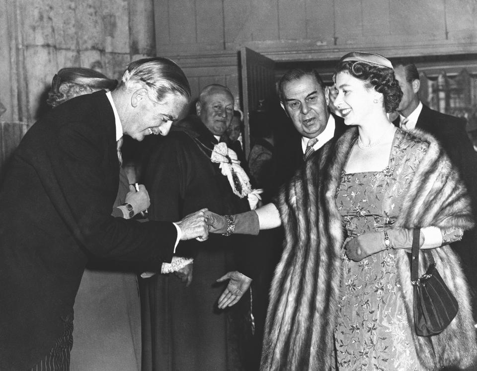 FILE - In this May 15, 1956 file photo, British Prime Minister Anthony Eden, bows as he welcomes Queen Elizabeth II on her arrival at London's Guildhall, during the 40th anniversary celebration of the National Savings Committee. Queen Elizabeth II, Britain’s longest-reigning monarch and a rock of stability across much of a turbulent century, has died. She was 96. Buckingham Palace made the announcement in a statement on Thursday Sept. 8, 2022. (AP Photo, File)