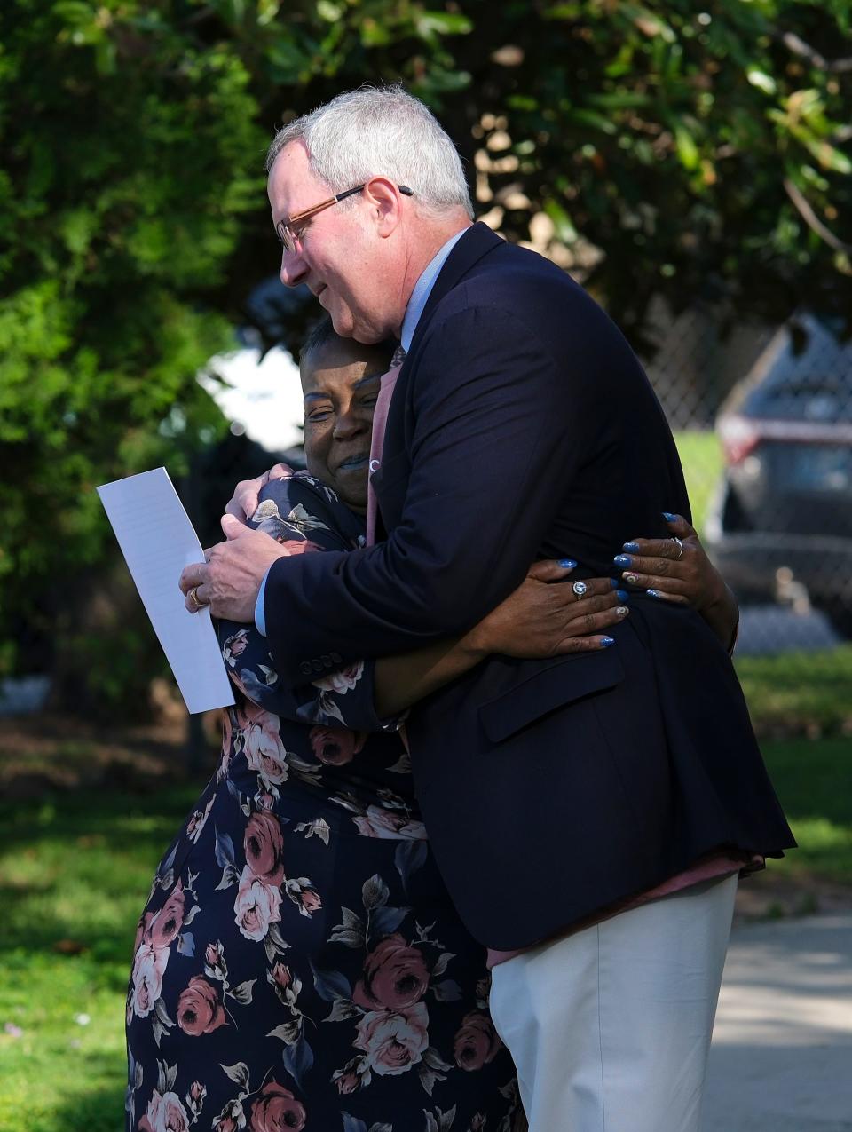 Sanctuary client Romaine Fantroy hugs Patrick Raglow, executive director, on Tuesday after speaking at the groundbreaking ceremony for the new Catholic Charities Sanctuary Women's Development Center.