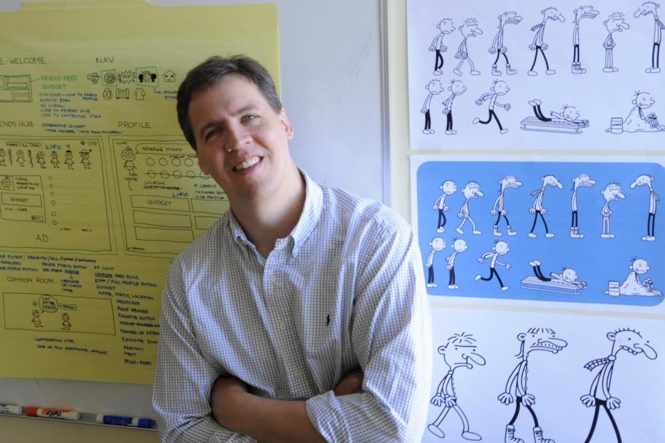 Jeff Kinney leans against a wall in his office.