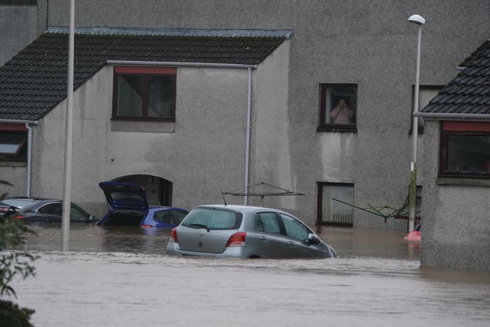 A person looks from a window at flood water in Brechin, Scotland (Andrew Milligan/PA Wire)