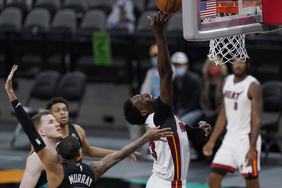 Miami Heat center Bam Adebayo (13) drives to the basket past San Antonio Spurs guard Dejounte Murray during the second half of an NBA basketball game in San Antonio, Wednesday, April 21, 2021. (AP Photo/Eric Gay)