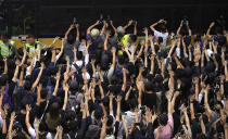 Supporters surround a police bus carrying political activist Edward Leung as it leaves the High Court in Hong Kong, Wednesday, Oct. 9, 2019. Several hundred masked protestors chanting for revolution have gathered at Hong Kong's High Court for the appeal hearing of an activist sentenced to six years in prison for his part in a violent nightlong clash with police. (AP Photo/Vincent Yu)