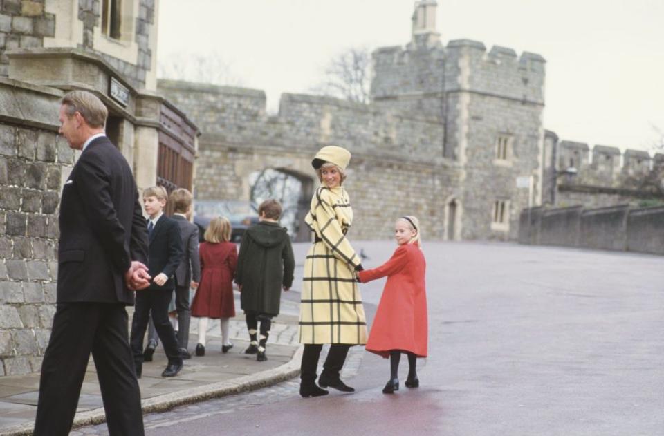<p>A traditional British Royal Family Christmas during Diana's day included a church service at St. George's Chapel on the grounds of Windsor Castle. Here, Diana is shown wearing an untraditional butter yellow and black color scheme while holding hands with Lady Rose Windsor on Christmas Day in 1987. </p>