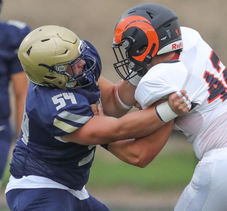 Hoban offensive lineman Nate Cross puts a block on a Erie Cathedral Prep defender on Friday, Aug. 26, 2022 in Akron, Ohio, at Dowed Field.
