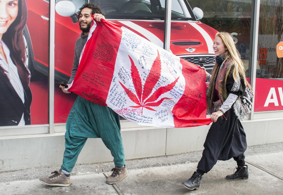 Unas personas sostienen una bandera de Canadá con una hoja de marihuana en Montreal, el miércoles 17 de octubre de 2018. (Graham Hughes/The Canadian Press via AP)